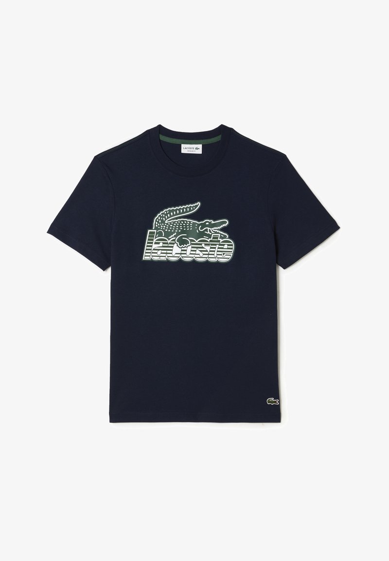 Námořnické bavlněné tričko s grafikou zeleného a bílého krokodýla a textem "Lacoste" pod ním. Krátké rukávy a kulatý výstřih.