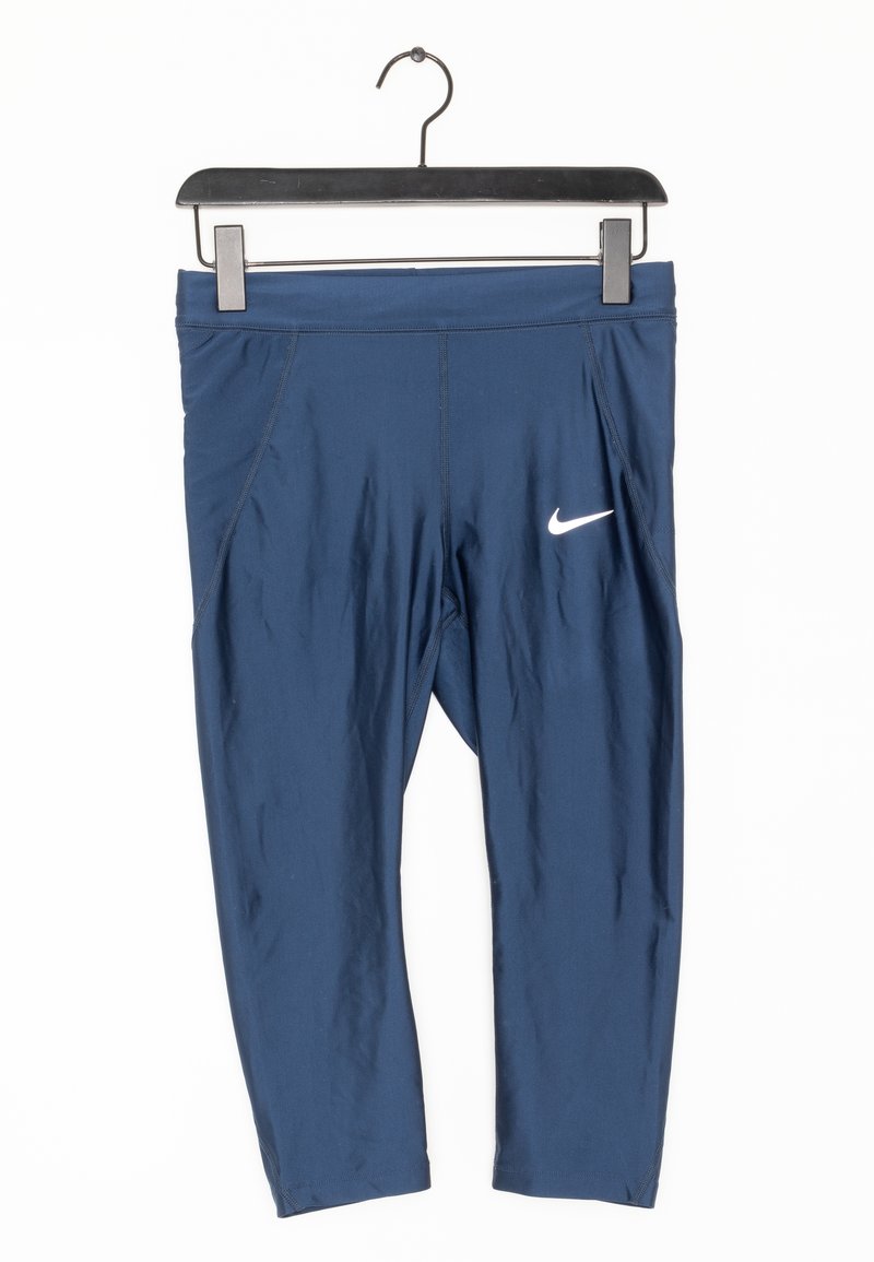 Námořnické modré krátké legíny Nike s bílým logem swoosh, visící na černém ramínku na bílém pozadí.
