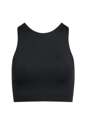 Mosolygó nő fekete ujjatlan rövid felsőt és sötétzöld, elasztikus derékpántos nadrágot visel, egyszínű világos háttér előtt.