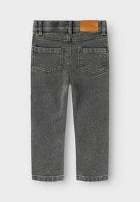 Hallide denim püksid sileda tekstuuriga, tagaküljel taskud ja pruun nahklabel vööl. Üksik jalgade disain.