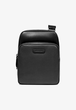 Zaino in pelle nera con texture liscia, dotato di chiusura superiore con zip e una piccola tasca esterna con un logo discreto.