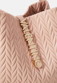 Borsa a mano in pelle rosa con texture trapuntata e motivo intrecciato. Finiture in oro con la scritta "VALENTINO" attaccata alla tracolla.