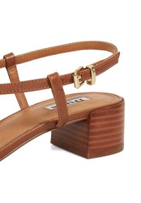Sandale à talons bruns avec fines lanières, détail de boucle en or et talon bloc avec une texture semblable à du bois. Tige et semelle en cuir lisse.