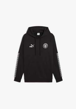 Musta kapuutsiga, millel on känguru tasku, valge Puma logo, "KING" tekst ja Manchester City embleem; külgedel on mustriga valged triibud.