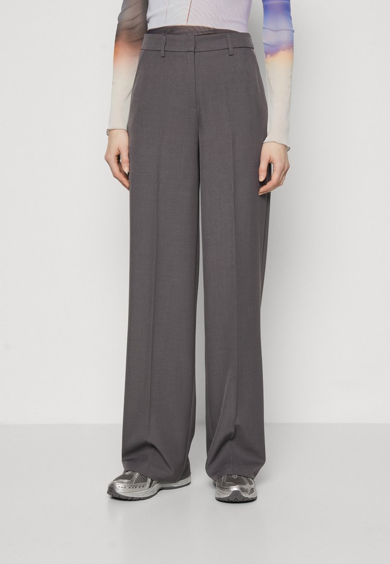 Pantaloni grigi a vita alta con un design a gamba dritta, realizzati in un tessuto morbido. Presentano passanti per cintura e una vestibilità sartoriale.
