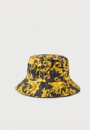 Cappello a secchiello nero e oro con motivo barocco ornato e testo ricamato "Jeans Couture" sul davanti.