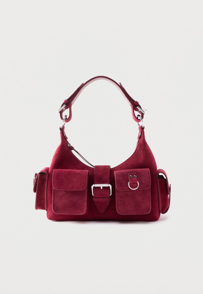 Μικρή τσάντα χειρός από σουέντ μπορντό με κοντή λαβή, μπροστινό κούμπωμα, δύο μπροστινές τσέπες με καπάκι και πλαϊνές τσέπες με κουμπώματα.