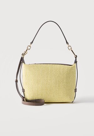 Borsa rettangolare intrecciata di colore giallo chiaro con tracolla in pelle marrone scuro e ferrature dorate, mostrata su uno sfondo chiaro e uniforme.