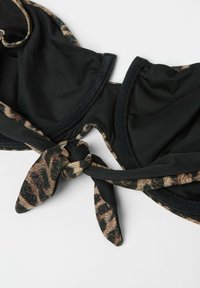 Top de bikini negro con detalles de estampado de leopardo. Presenta un material suave, un lazo retorcido en la parte delantera y copas moldeadas para mayor soporte.