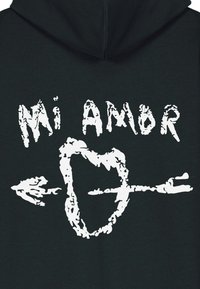 Felpa nera con cappuccio con scritta grafica bianca "Mi Amor" e una forma di cuore trafitto da una freccia. Texture liscia, design moderno.