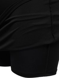 Μαύρο αθλητικό σορτς με επικάλυψη υφάσματος φούστας πάνω από εφαρμοστά σορτς με ορατή ραφή.