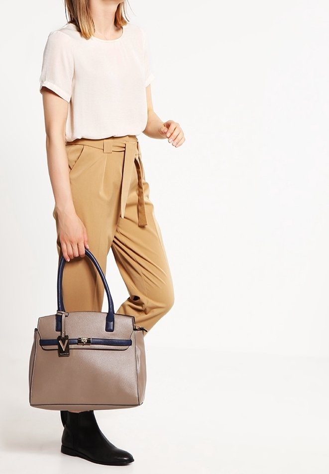 Beige kabelka s námořnickými akcenty, strukturovaný design, dvě horní ucha, přední kapsa na zip a kovový detail s logem.