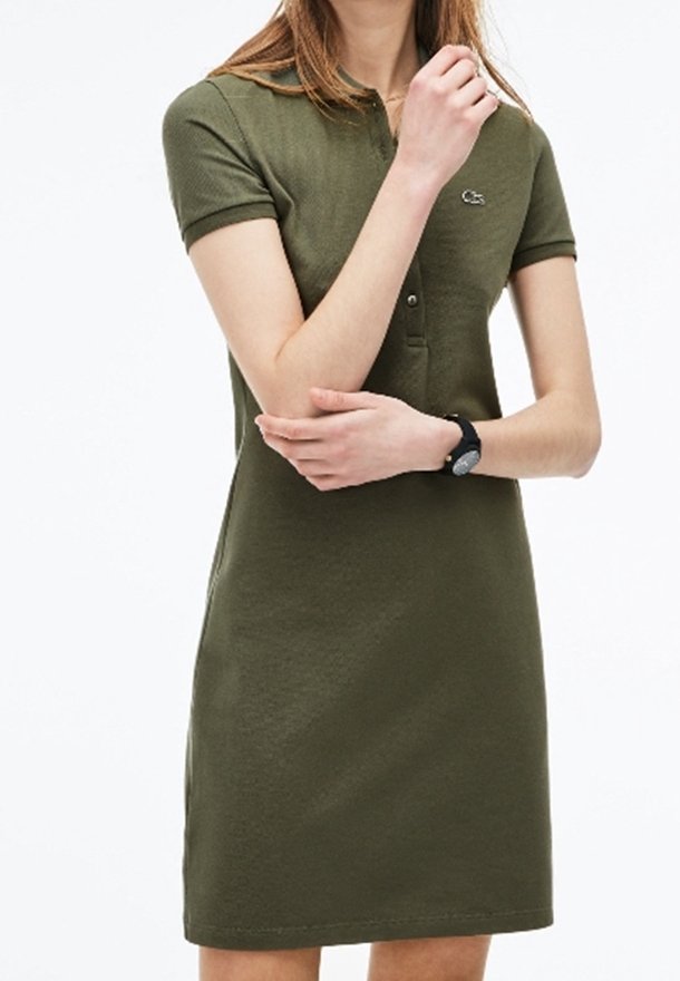 Grünes Polokleid aus Baumwolle, mit Kragen, kurzen Ärmeln, einer Knopfleiste mit drei Knöpfen und einem kleinen Logo auf der Brust.