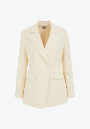 Beige skräddarsydd kavaj med slagkrage, enkel knappstängning och två framfickor. Slät textur med en strukturerad silhuett.