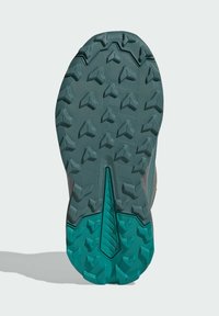 Trail shoe outsole with deep grip patterns; composed of rubber in teal color with textured sections for traction and stability.