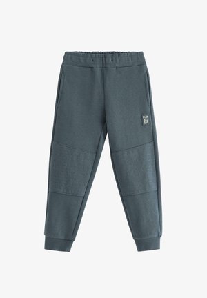 Mørkegrå joggebukser lavet af struktureret stof med elastisk talje, sidelommer og vandrette ribbede detaljer på benene.