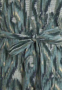 Mönstrad klänning i nyanser av grön, kräm och marinblå med en texturerad finish, med knappstängning fram och ett knytbälte i midjan.