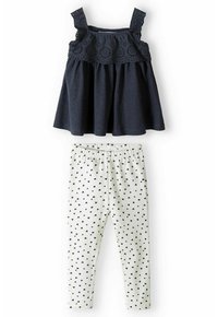 Mørkeblå tank top med blondekant og brede stropper, parret med hvide leggings med sorte hjerte mønstre. Blødt bomuldsmateriale.