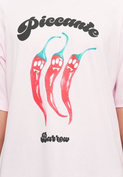 Svetloružové bavlnené tričko s grafikou troch červených chilli papričiek s tyrkysovými stonkami a bielymi pazúrikmi, doplnené čiernym textom.