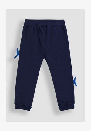 Tumesinine spordipüksid, mis on valmistatud puuvillast, külgedel on sinine kala kuju aplikaat, ribidega sääreotsad ja veniv vöökoht.