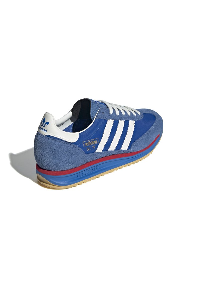 Baskets en suède bleu avec accent à trois bandes blanches, semelle intermédiaire rouge et semelle en caoutchouc. Comprend des lacets plats blancs et un détail logo doré.