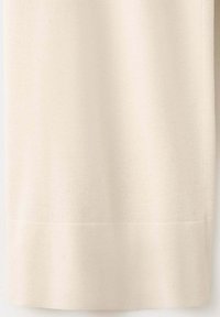 Tissu beige clair avec une texture tissée subtile et une couture horizontale près du bord inférieur.