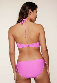Set di bikini rosa con scollo all'americana, legature e chiusura a gancio, texture liscia e laccetti laterali regolabili sul pantalone.