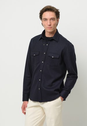 Donkerblauw overhemd met knopen, gemaakt van zachte stof, met een klassieke kraag, twee borstzakken en metalen knoopaccenten.