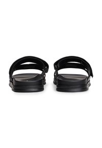 Μαύρα σανδάλια με δύο φαρδιές λουρίδες, επίπεδη σόλα και μινιμαλιστικό σχεδιασμό. Το υλικό φαίνεται συνθετικό με λείο υφή.