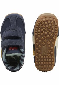 Tumed sinine nubukist beebijalats, millel on Velcro rihm, kummist põhi, valge triibuga detail ja mustriline sisemus. Omab "SURF" brändi.