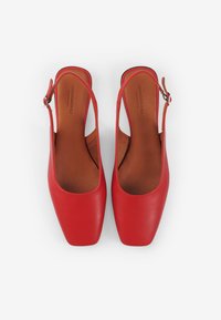 Des chaussures slingback en cuir rouge avec un bout carré et des côtés ouverts. Semelle intérieure en cuir marron. Boucle ajustable au niveau du talon.