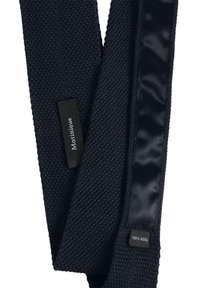 Bufanda de lana azul marino tejida con un patrón texturizado, que presenta una parte inferior de satén suave. Las etiquetas indican la marca y el material: "Martinique" y "100% Lana."