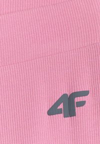 Tissu côtelé rose avec un logo noir "4F" imprimé près du coin inférieur droit.