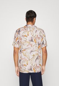 Camicia a maniche corte in tessuto leggero con un motivo a spirale nei toni crema, arancione e marrone. Vestibilità rilassata con colletto da campeggio.