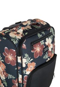 Valise à roulettes noire imprimée de fleurs avec des motifs d'hibiscus et de feuilles, en tissu durable, dotée de plusieurs compartiments zippés et d'une poignée robuste.