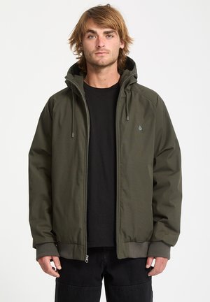 Olive green zip-up jacket with a hood, featuring ribbed cuffs and a front pocket. Smooth texture and minimalistic design with a logo accent.