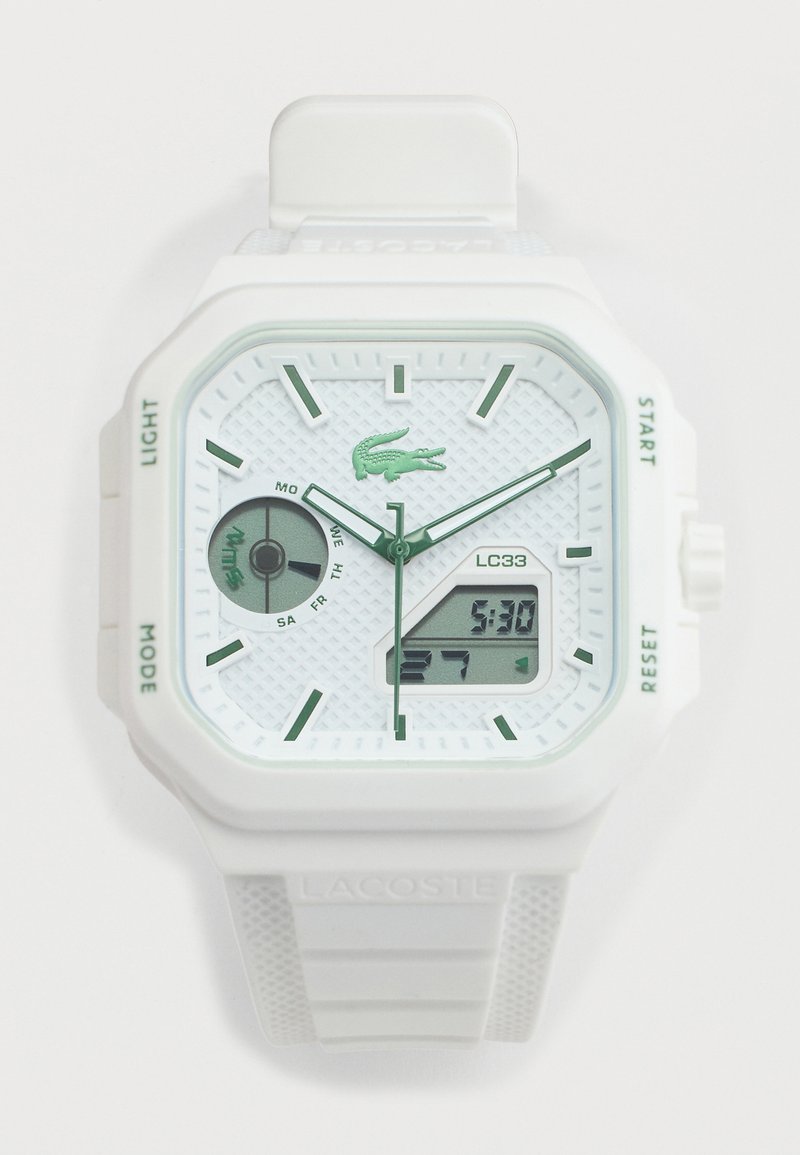 Λευκό ρολόι χειρός Lacoste με αναλογική και ψηφιακή οθόνη, πράσινους δείκτες ωρών, ένδειξη ημέρας και υφασμένο λουράκι με λογότυπο.