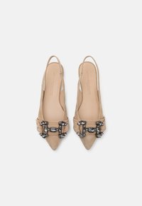 Nude zamszowe obcasy slingback z ostrymi noskami i ozdobnymi, cekinowymi klamrami, posiadające gładką wkładkę i otwarty tył.