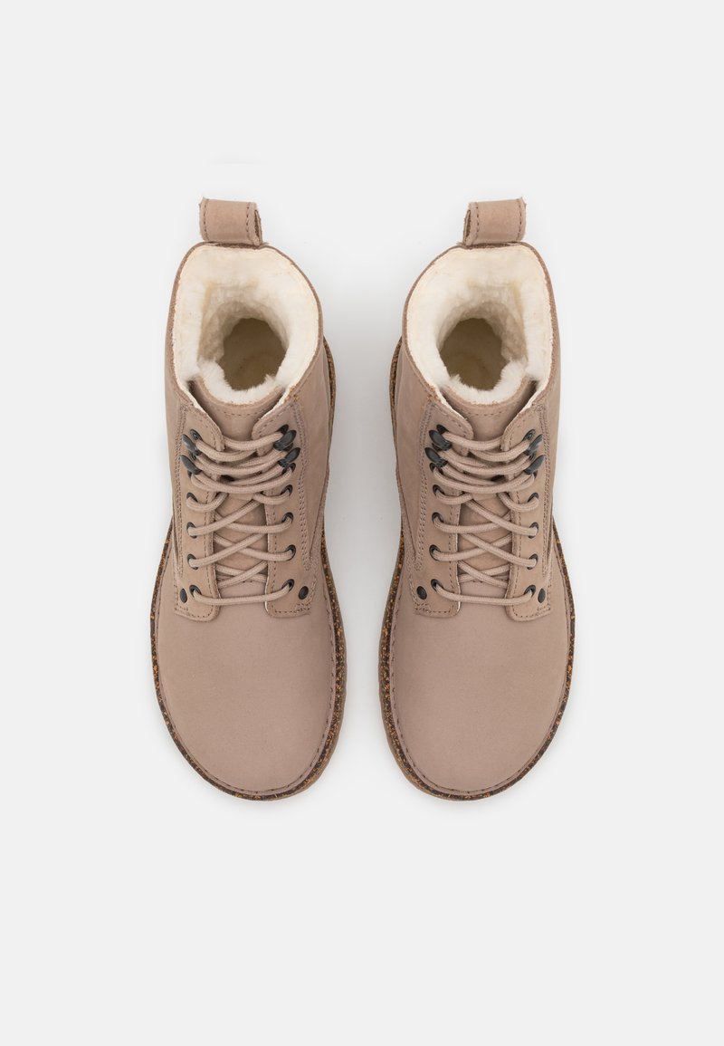 Beige Knöchelstiefel aus strukturiertem Leder mit Kunstfellfutter, schwarzen Schnürsenkeln, runder Spitze und gestickter Gummisohle.