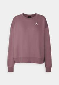 Lila bomullströja med rund halsringning, ribbade ärmslut och nederkant. Har en vit Jordan-logotyp på bröstet. Slät textur.