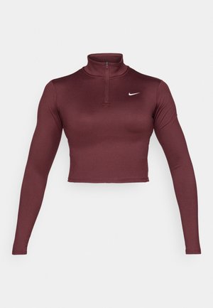Crop top long à manches marron avec un col montant et une fermeture éclair demi-longueur. Texture lisse avec un logo Nike blanc sur la poitrine gauche.