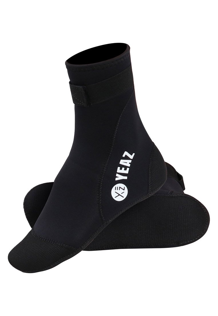 Svart neopren vattenskor med medelhög design, gummisula, kardborreband och vitt logotyp på sidan. Slät textur och flexibel.