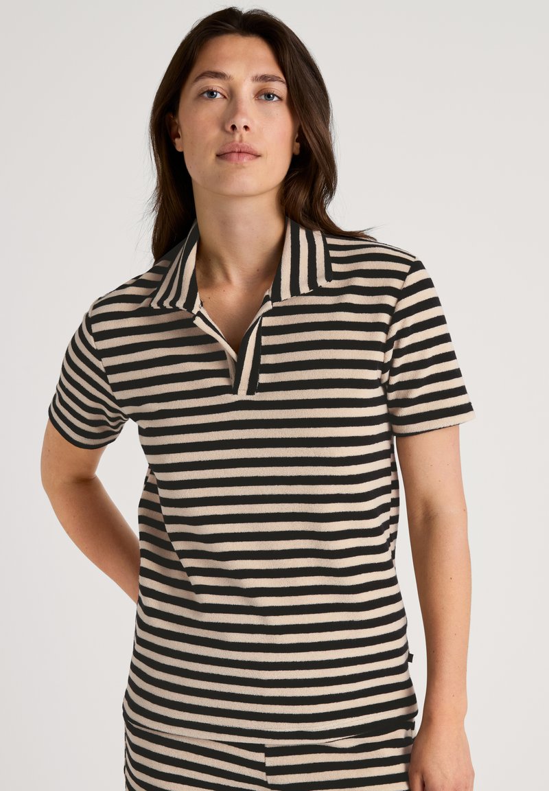 Gestreepte poloshirt in beige en zwart, met een kraag en korte mouwen. De stof lijkt zacht met een gladde textuur.