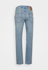 Jeans de mezclilla Levi's azules vistos desde atrás, con costuras clásicas, dos bolsillos traseros y una etiqueta de cuero de la marca en la cinturilla.
