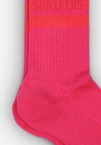Calcetines de color rosa brillante con textura de canalé y franjas horizontales naranjas contrastantes. Presentan refuerzos en la zona del talón y de los dedos, etiquetados como "SCALPERS".