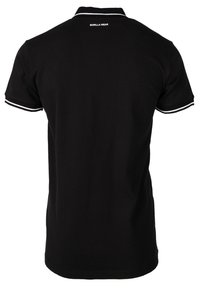 Zwarte poloshirt van katoen met een klassieke kraag. Heeft witte accenten op de mouwen en logo-tekst op de achterkant. Eenvoudig ontwerp.