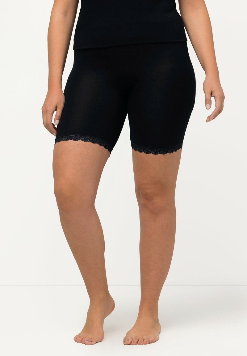 Zwarte stretchshorts met een gesculpteerd kanthem, gemaakt van een zachte, lichte stof, die snugly rond de bovenbenen en heupen zit.