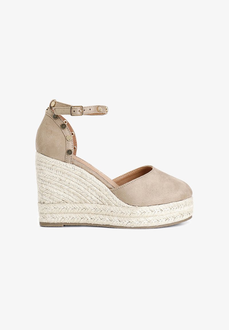 Scarpa wedge in suede beige con cinturino alla caviglia, caratterizzata da dettagli in metallo dorato e una piattaforma in corda intrecciata. Punta arrotondata e superficie testurizzata.