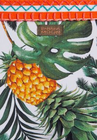 Tecido estampado com folhas verdes e um design de abacaxi, com detalhes em ponto laranja e verde-água. O rótulo da etiqueta diz "Banana Moon."