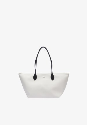Sac tote blanc en matériau lisse, avec des poignées supérieures noires et des accents noirs, fermeture éclair et logo au centre.